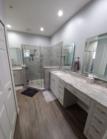 Modern bathroom with glass shower and marble countertop.