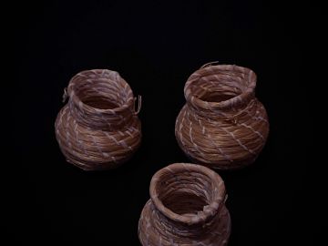 Three small woven baskets with a dark background.