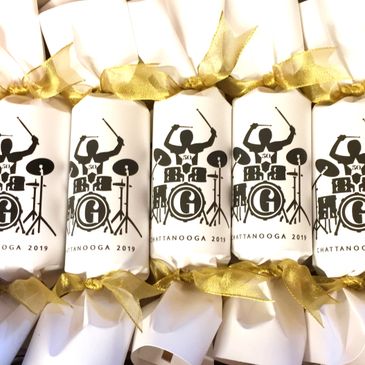 White party favors with a drummer logo and gold ribbons from Chattanooga 2019 event.
