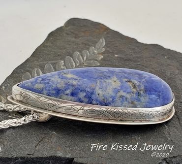 Stellar Lapis teardrop cab set in sterling and fine silver with hand-etched bezel and hidden bail.
