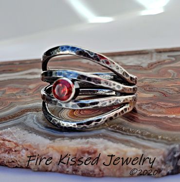 Faceted garnet set in handformed, organically shaped and textured sterling silver band.