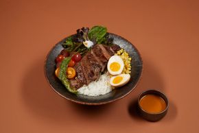 Seared soy-marinated flank steak served w/ white rice, furikake corn, cherry tomato, chili oil marin