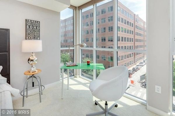Bright modern corner office with glass walls and city views.