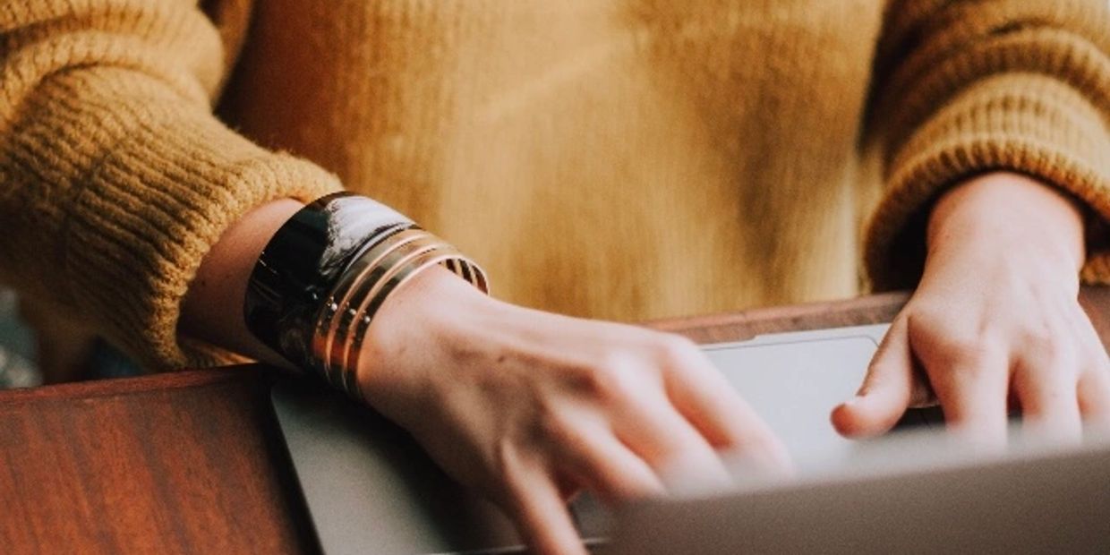 Female business consultant sitting at a desk typing on her laptop