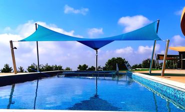 Large Shade Sail over a pool providing sun shade in Peyia, Paphos, Cyprus. By Shadeports Plus.