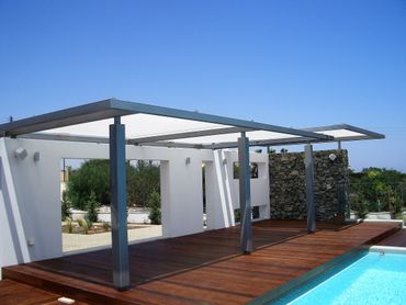 pergola cover/pergola shade providing sun shade next to a swimming pool by Shadeports Plus Cyprus.
