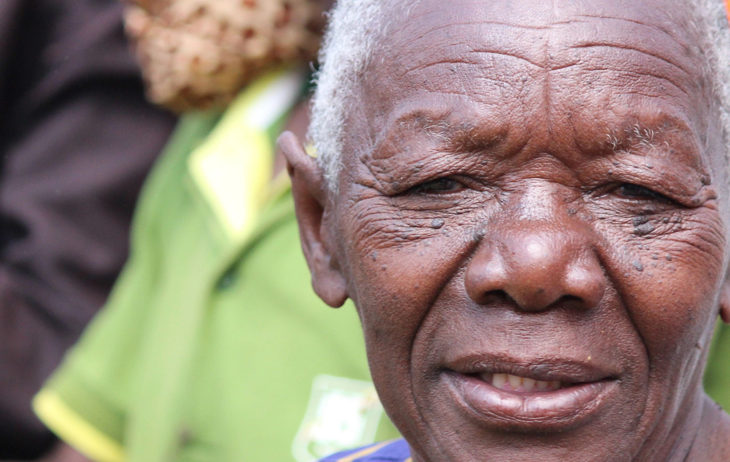 Close-up of an elderly man's face with a slight smile.