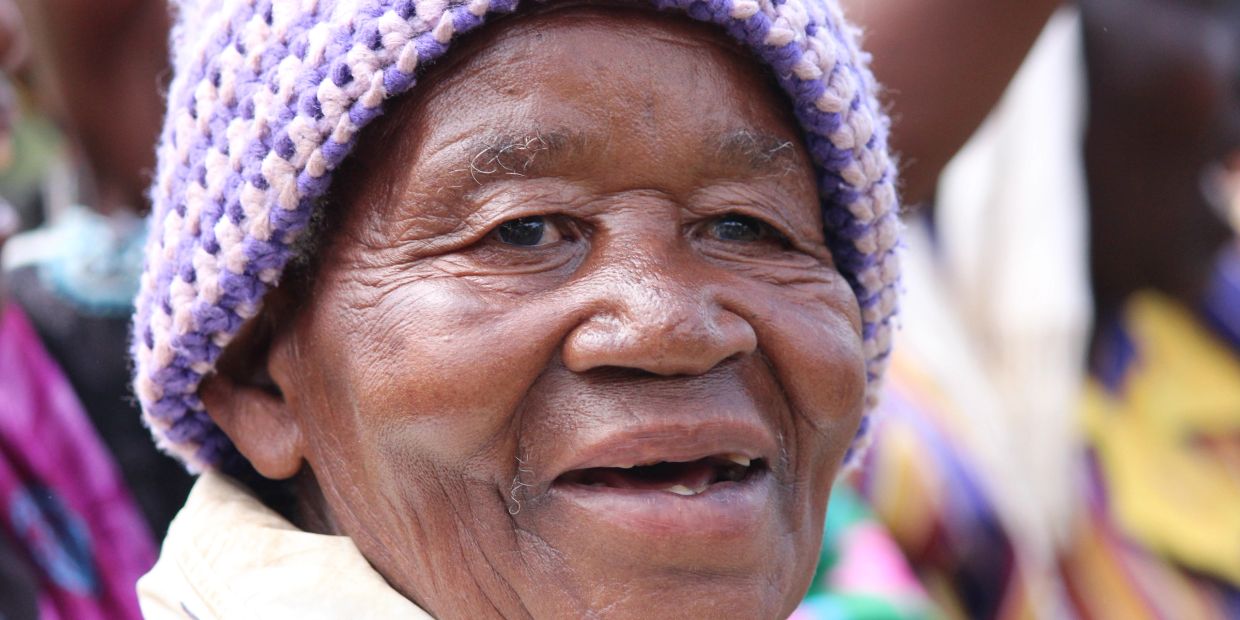 Smiling elderly person wearing a knit hat.