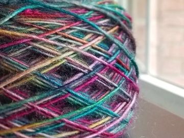 A skein of Trolltunga on Veil singles base caked up next to a window.