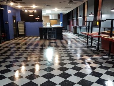 Empty room with black and white checkered floor and tables.