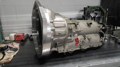 A vehicle transmission on a workbench in a garage.