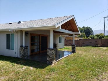 Home addition roof patio with wood ceiling planks, seamless roof extension & smooth concrete floor.