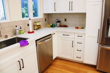 Small kitchen remodel, white quartz counters, modern black fixtures, stainless steel appliances.