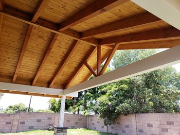 Home addition roof patio with wood ceiling planks, seamless roof extension & smooth concrete floor.