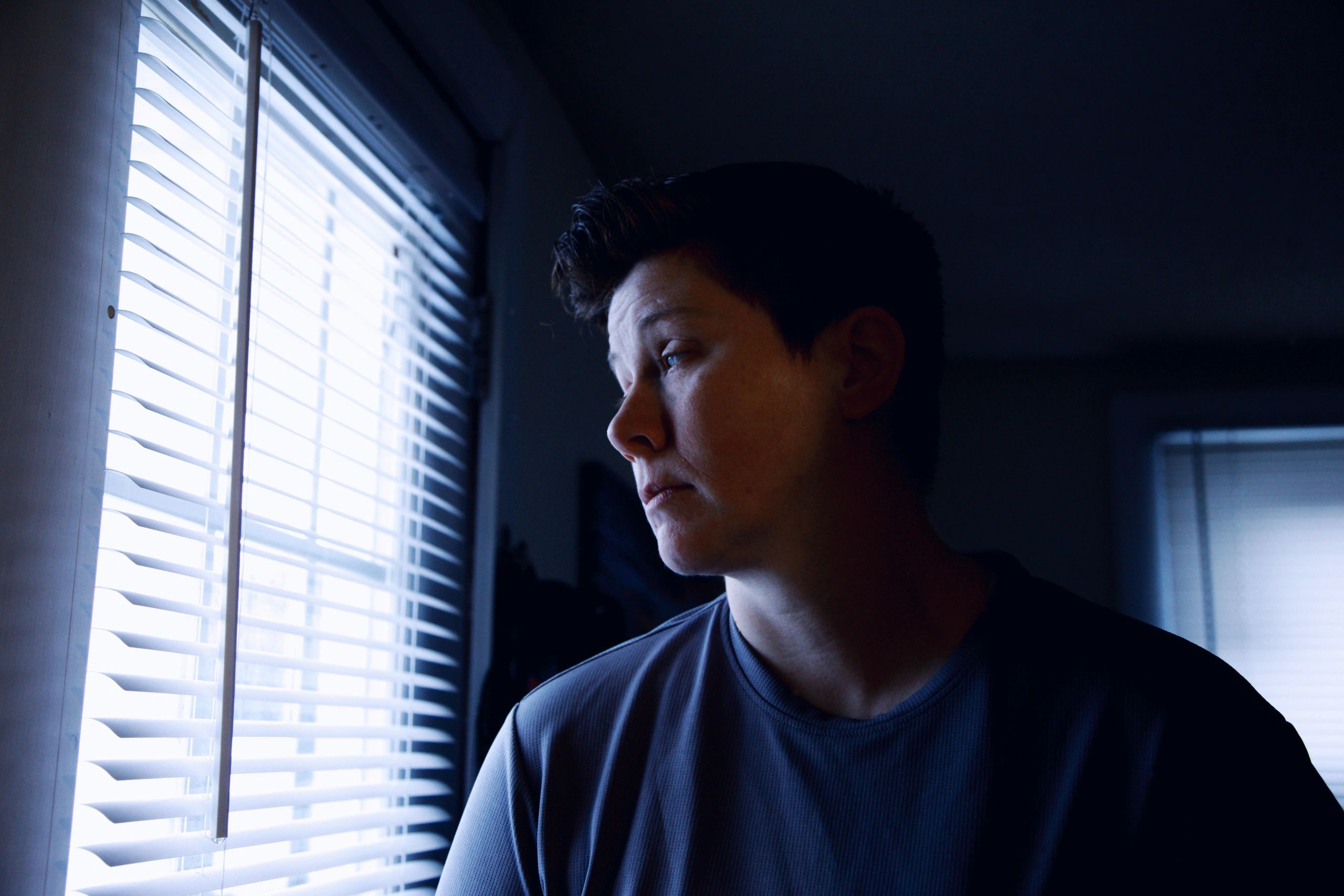 Sad young woman gazing out of window.