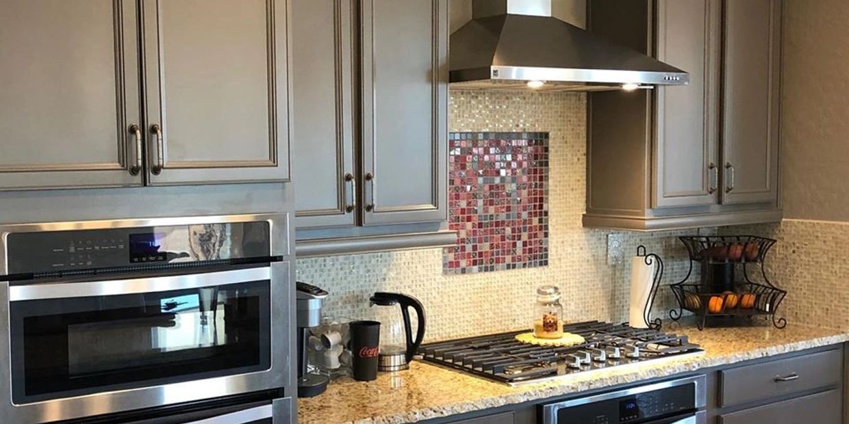 Modern kitchen with stainless steel appliances and granite countertops.