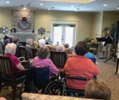 Seniors attending a musical performance in a cozy room.