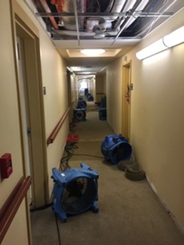 drying equipment in hallway of hotel after major water damage 