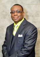 Man in a dark suit and glasses.
