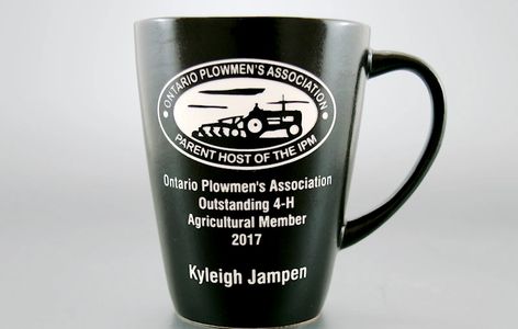Tapered ceramic mug with white lettering made using the sandcarving technique.