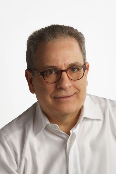 A man wearing eyeglass with white dress with looking ahead