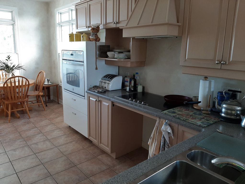 kitchen with a roll-under cooktop, universal-height wall oven module, and a 60" turning space