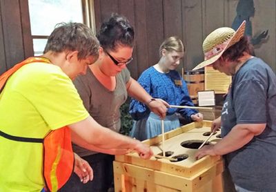 People making candles, a learning activity, in a museum.