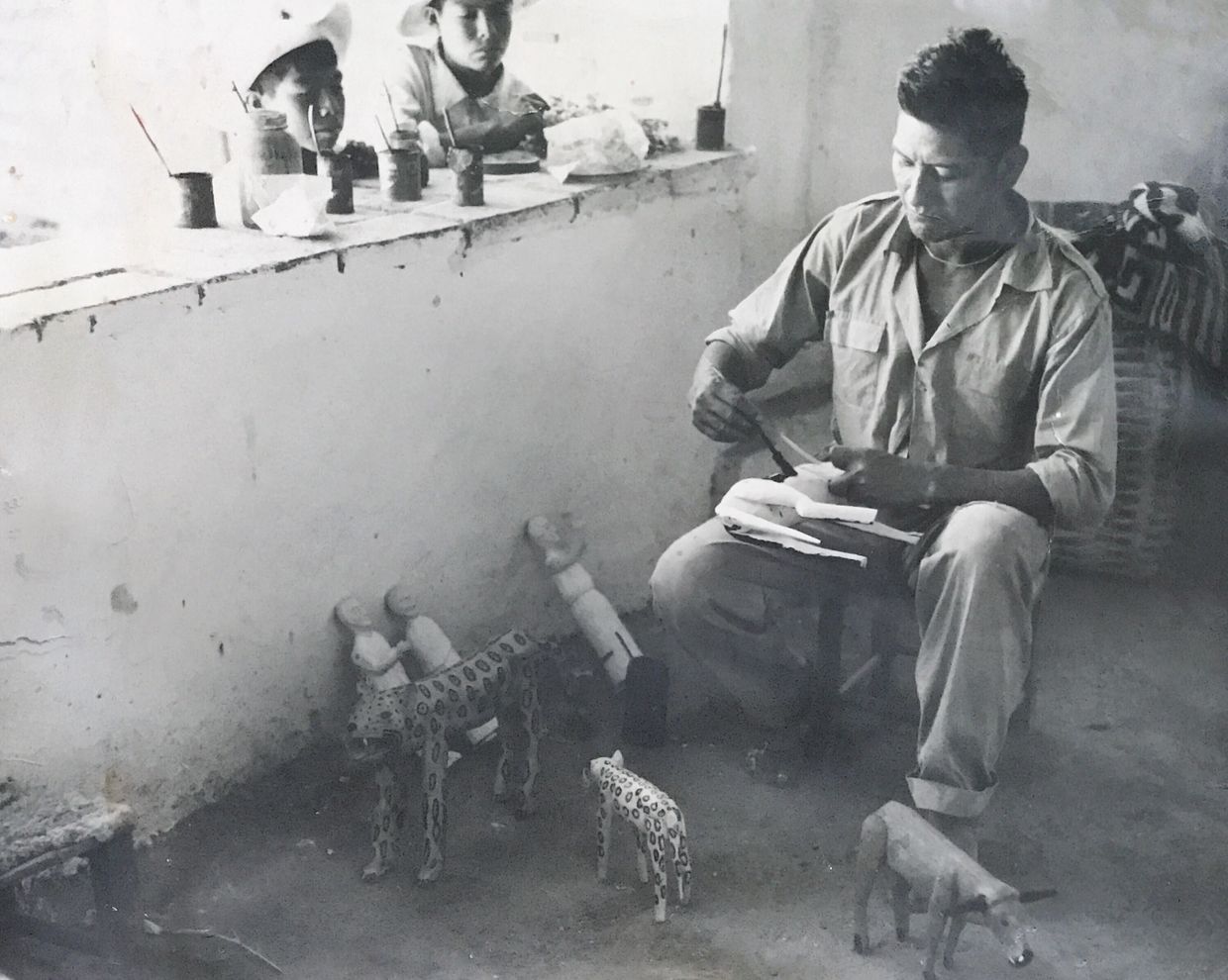 Fotografía de Don Manuel Jiménez, pintando algunas de sus obras en 1950s. Niños del pueblo observan.
