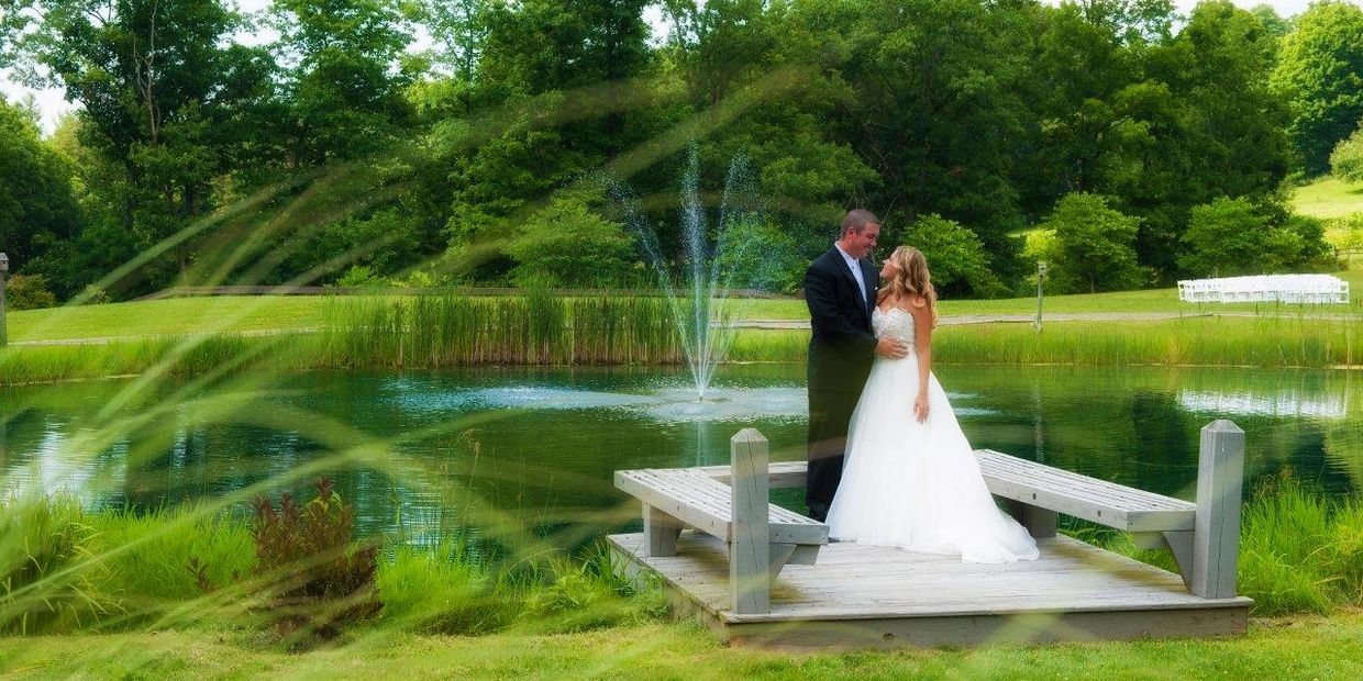 a bride and groom looking over our vineyard pond