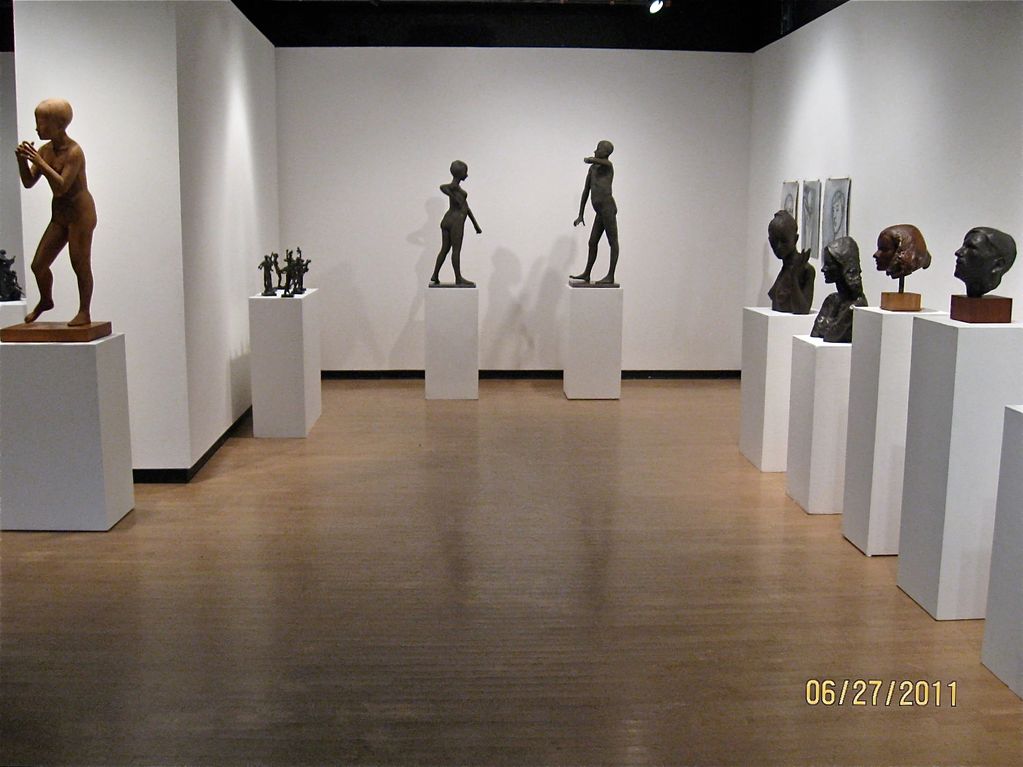 Bronze portraits and figures, one in wood in memorial exhibition