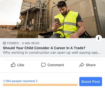 Construction worker in safety vest using phone.