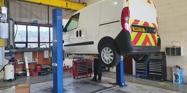 Two post vehicle lift being thoroughly examined