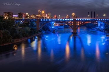 Minneapolis skyline from the U of M pedestrian bridge. 35W bridge and blues reflecting on the water