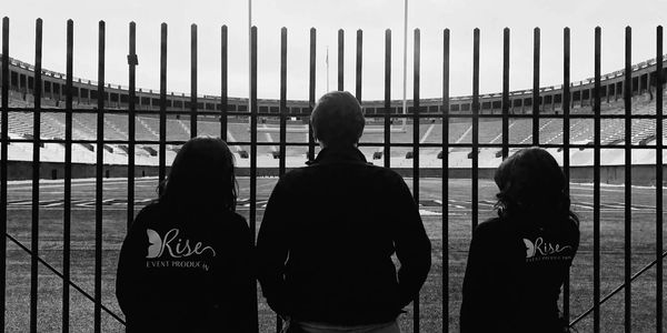 People planning event from behind fence