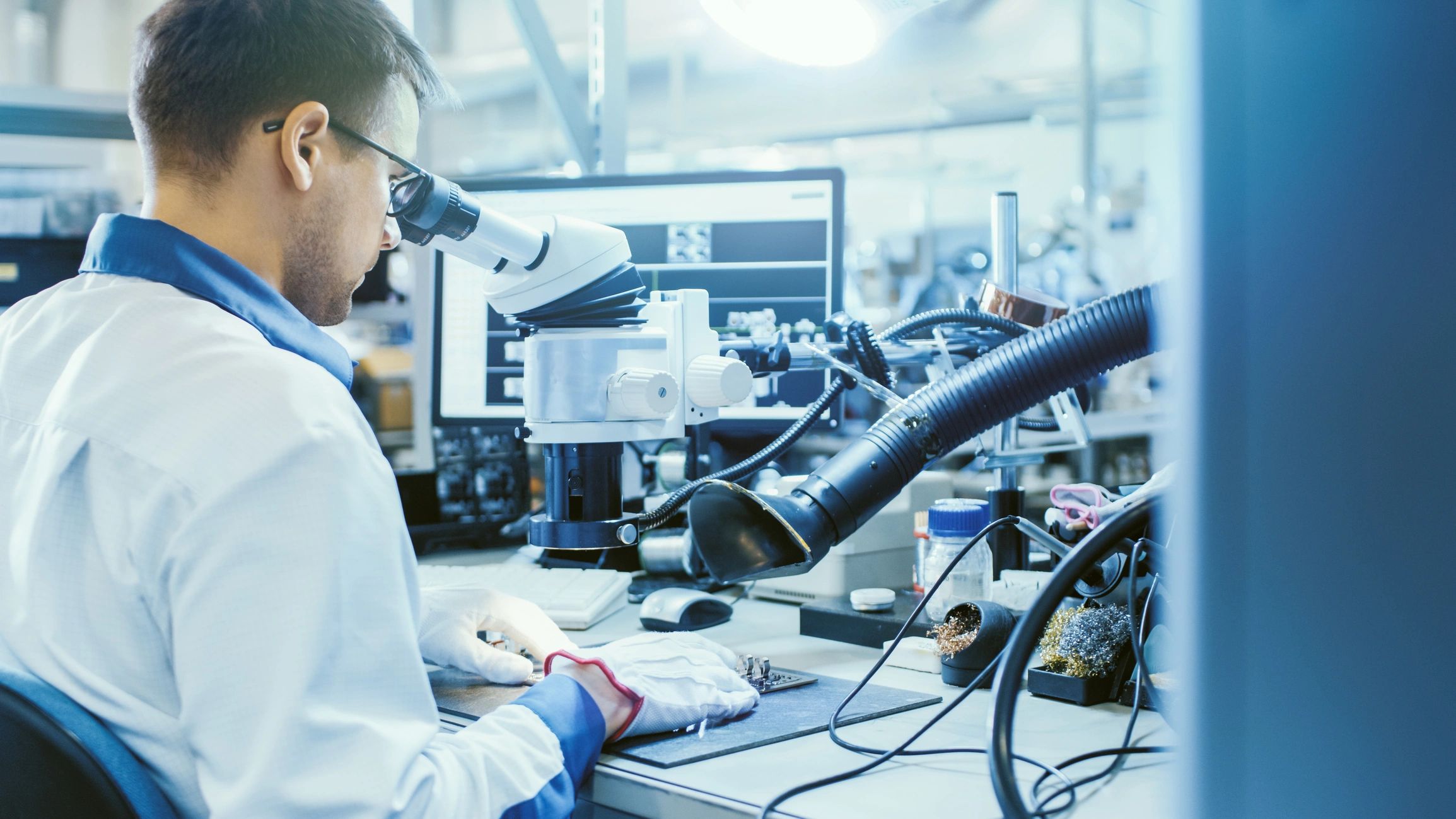 Male technician working with a stereo microscope