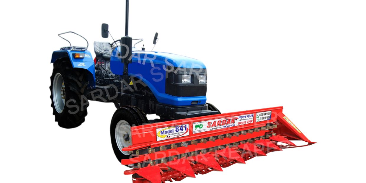 Blue tractor with red Sardar reaper attachment.