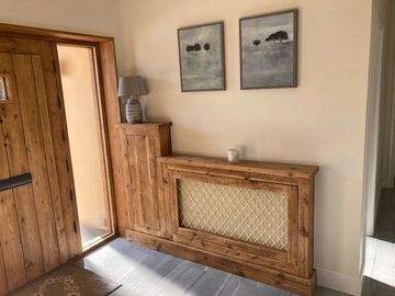 rustic wooden radiator cover and gas meter cupboard with brass mesh