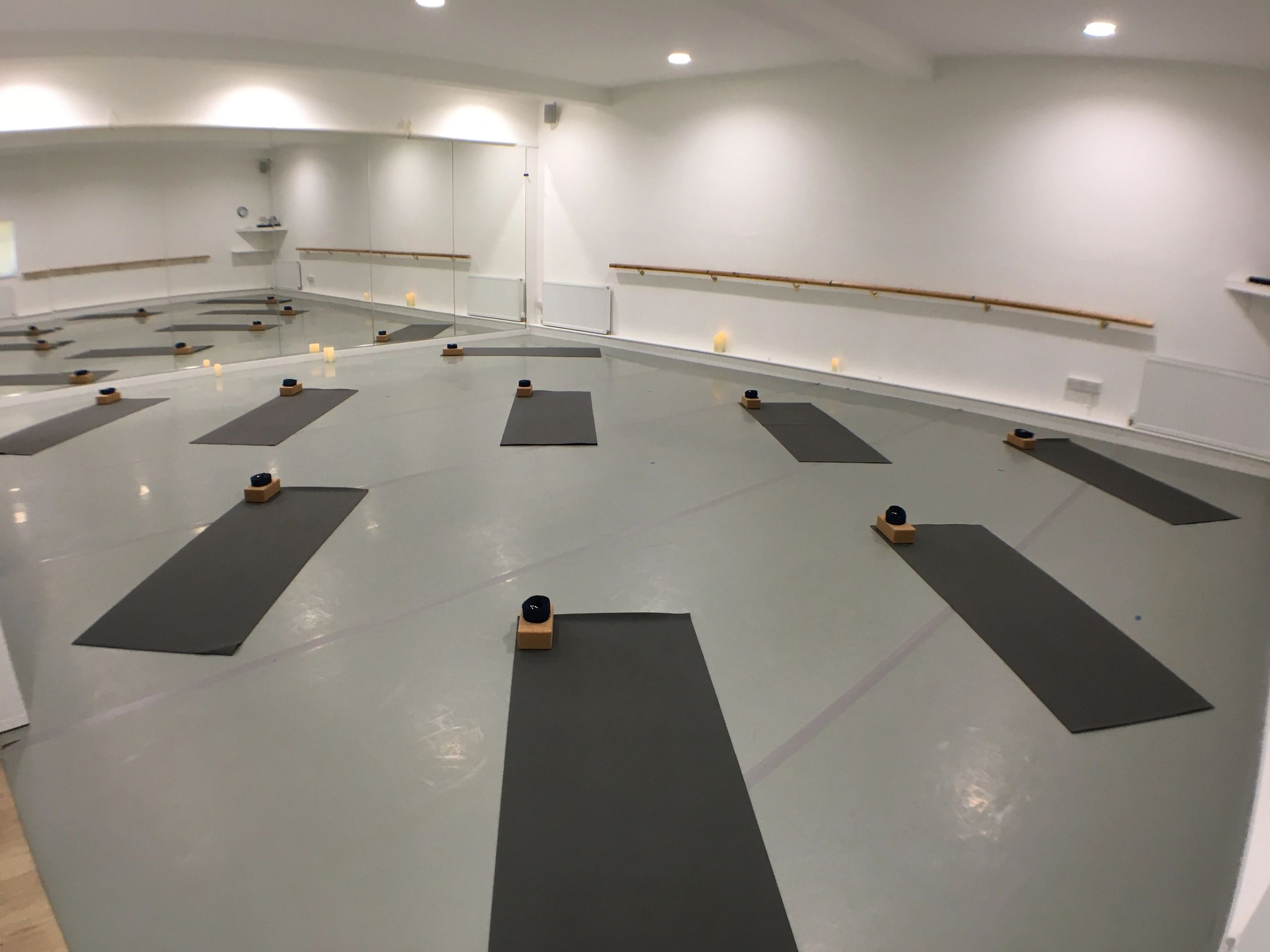 Yoga mats laid out in the yoga studio ready for a vinyasa yoga class, also known as Flow Yoga.