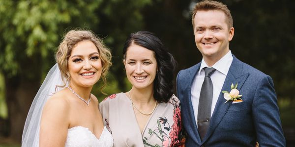 Auckland Wedding Celebrant Yvette Reid posing for photo with happy newlyweds