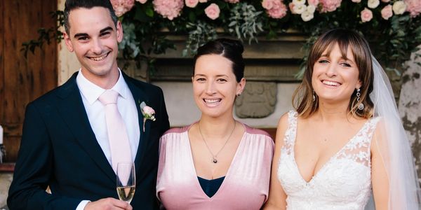 Auckland Wedding Celebrant Yvette Reid posing for photo with happy newlyweds