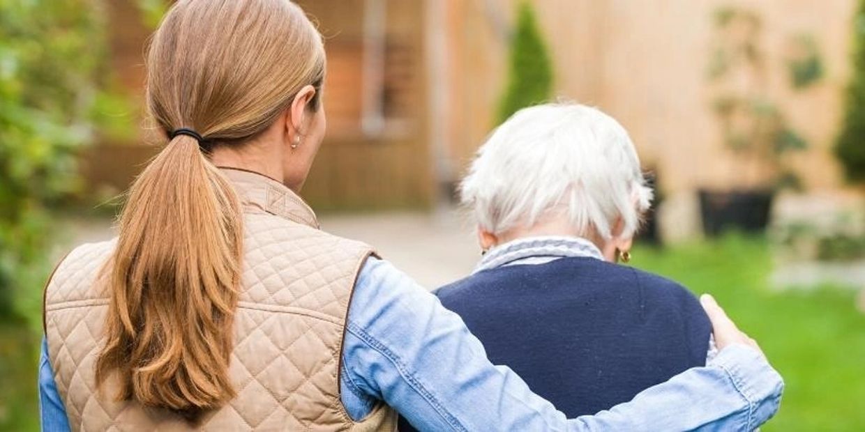 A girl supporting an old lady to make her walk.