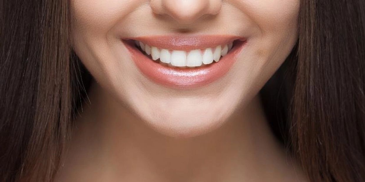 A girl smiling showing her healthy teeth.