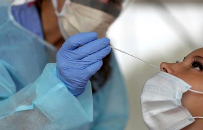 Healthcare worker administering a COVID-19 test.