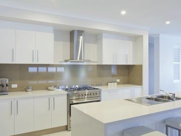 gold coloured glass kitchen splash back in white kitchen