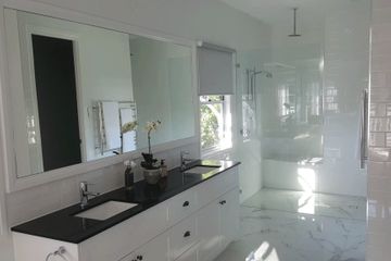 modern bathroom with frameless glass shower panel  large framed wall mirror