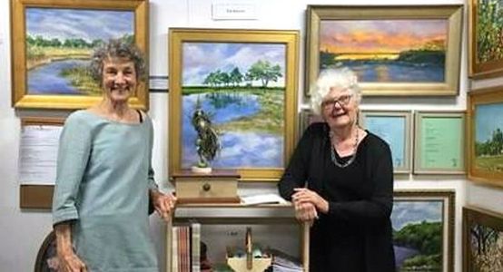 a photo of two smiling women in the Poetry Place section of Clinton Art Gallery, books & paintings