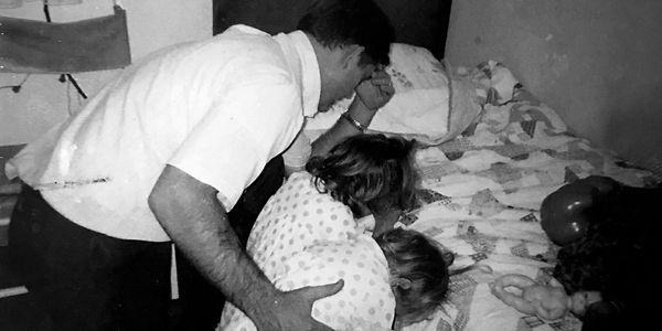 man praying with children