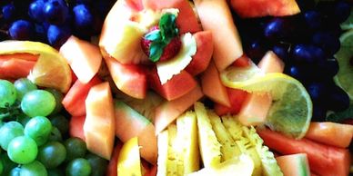A fesh array of  seasonal fruits, such as paw-paw, pineapple, melons, grapes,  strawberries and oran