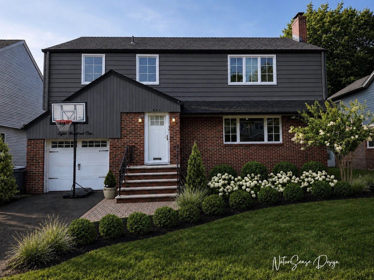 Modern front yard landscape with structured shrubs, a stone walkway, and a contemporary white home