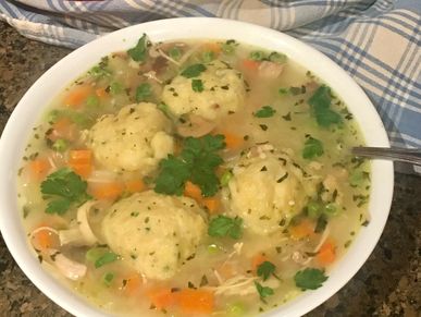 Chicken and dumplings served in a dutch oven and in a bowl.